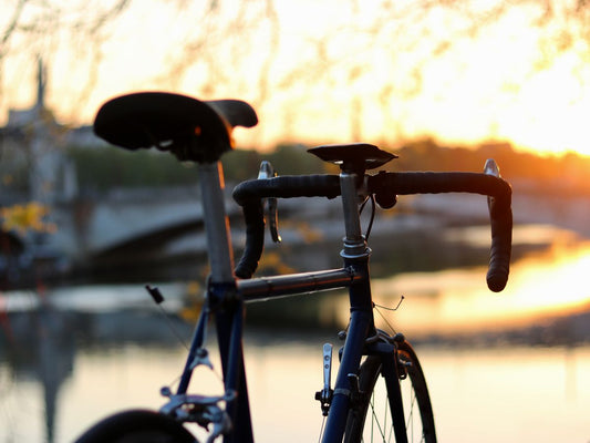 Cycliste sur route dégagée au lever du soleil, prêt pour une longue sortie avec équipement complet sur son vélo.
