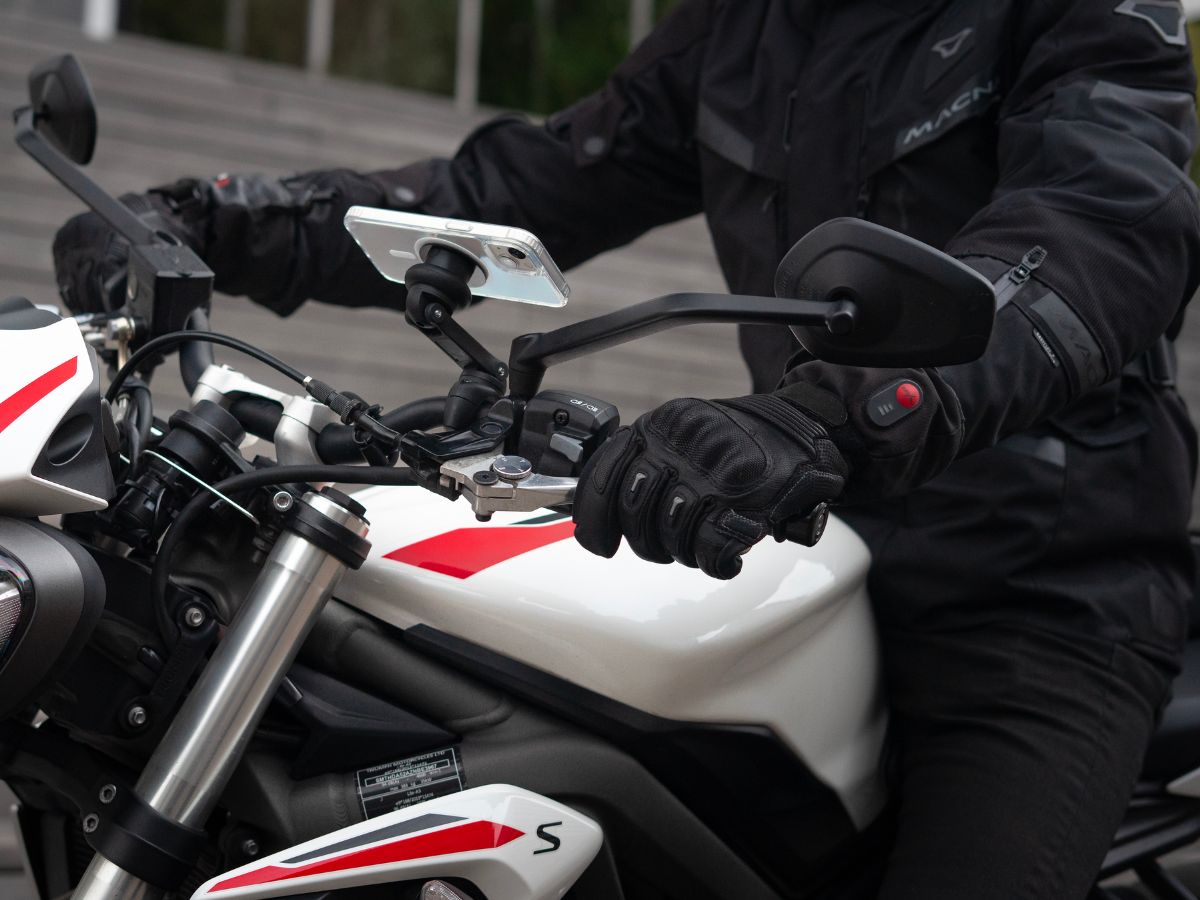 Un feu rouge avec un motard prêt à redémarrer, illustrant la nécessité de maîtriser ses départs. La posture du motard montre sa concentration avant de reprendre la route.