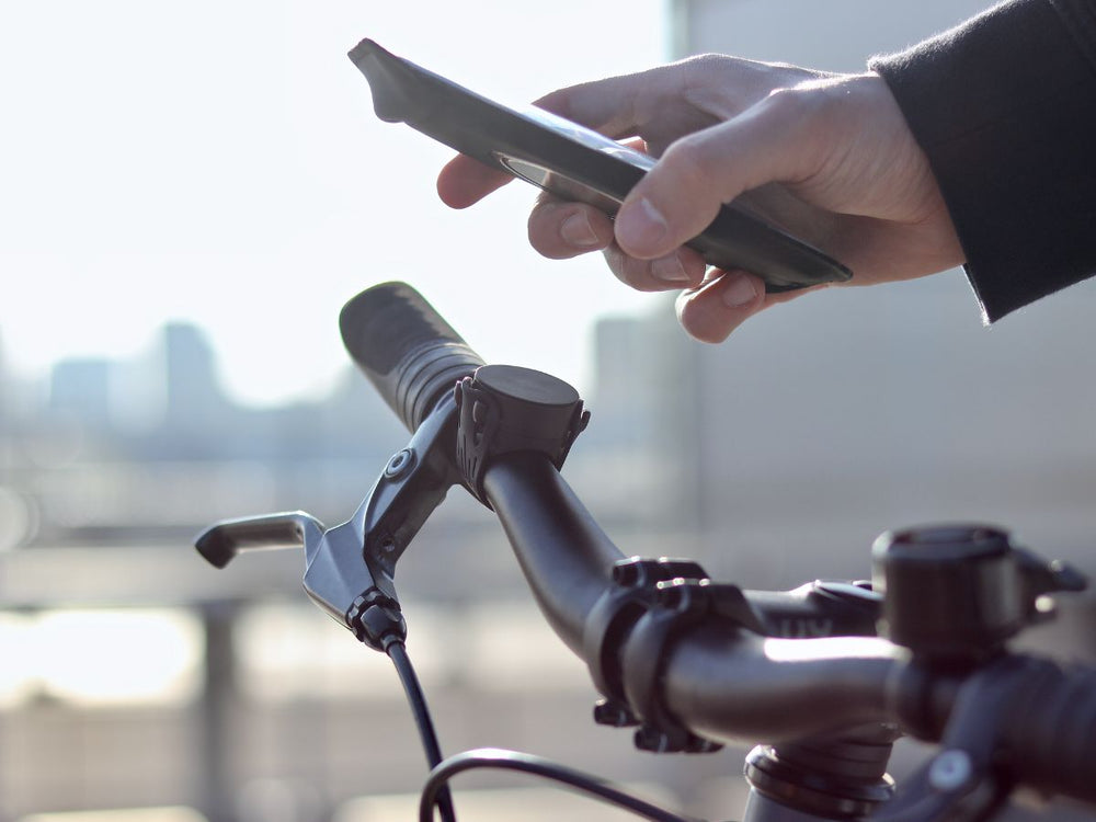 Mit der Smartphone-Halterung von Shapeheart für Fahrräder (und Roller) können Sie Ihr Smartphone in Sekundenschnelle an Ihrem Lenker befestigen und sich von Ihrem GPS führen lassen. Sie müssen Ihr Smartphone nicht mehr aus der Tasche holen, um sich zu orientieren.
