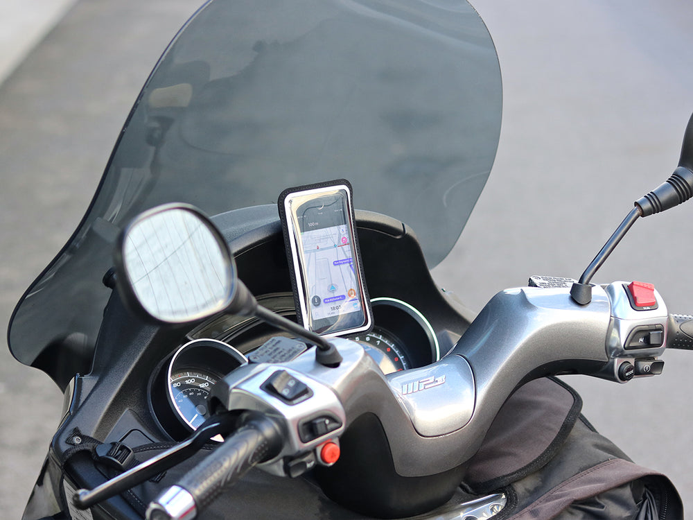 Il telefono viene fissato al cruscotto con il supporto per cruscotto per scooter. La custodia protegge il telefono dalle intemperie senza compromettere il tocco dello schermo. 